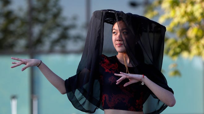A dancer from New U performs for the audience during an Asian American, Pacific Islander heritage celebration at Green Bay Packers' Titletown District on May 15, 2024, in Ashwaubenon, Wis.
