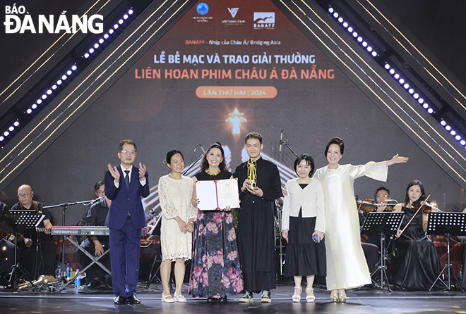 Da Nang Party Committee Secretary Nguyen Van Quang (1st, left) presenting the Best Film Award in the Asian film category to the film crew 