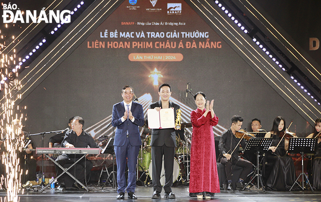 Chairman of the Da Nang People's Committee Le Trung Chinh (left) giving the Best Film Award in the Vietnamese film category to the film 