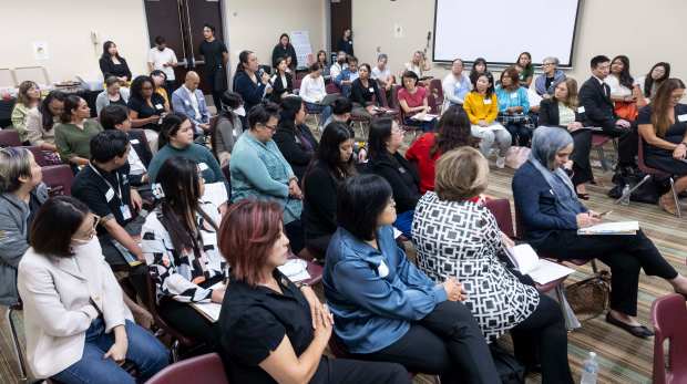 People listen to a Q&A during a press conference in...