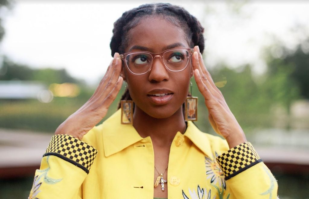 Aris Kian Brown is seen here with both hands pressed on both sides of her face 