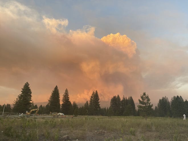 People parked their cars in the Grocery Outlet parking lot in south Weed on Tuesday evening, June 29, 2021 to watch smoke billow from the Lava Fire burning near Weed.