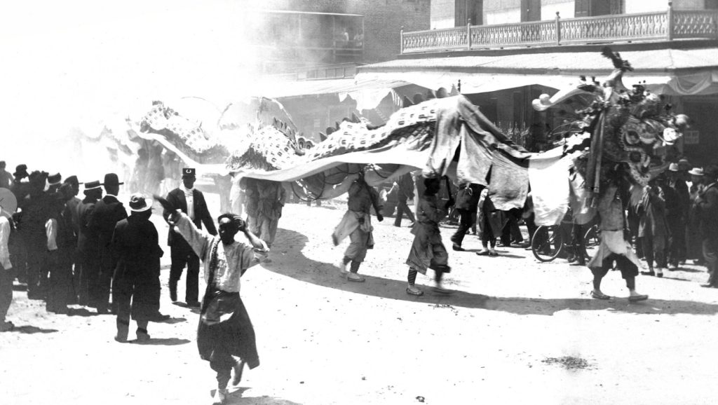 The dragon snakes down Fresno Chinatown. Chinese New Year celebration during early 20th century