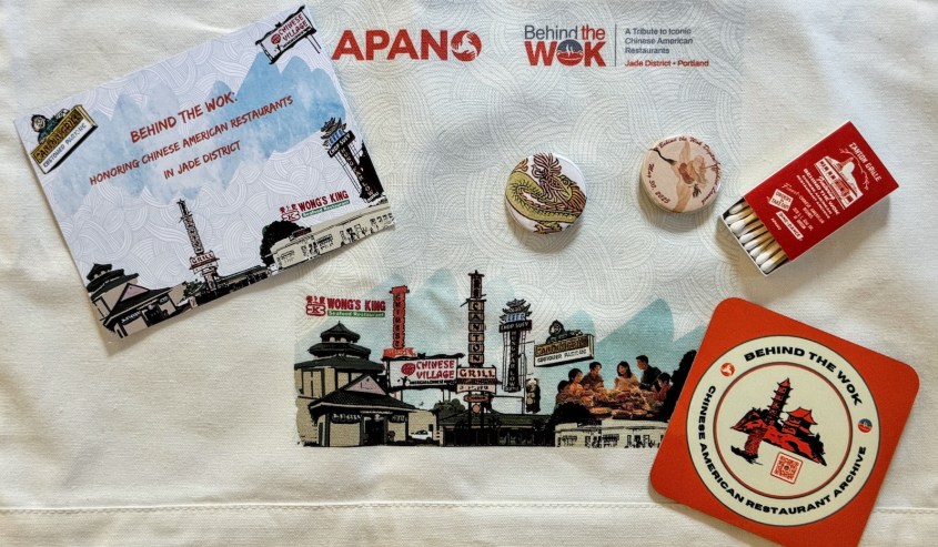 Promotional materials for APANO's online archive, including a card reading 'Behind the Wok: Honoring Chinese American Restaurants in Jade District,' coasters, buttons, and a matchbook featuring iconic restaurant illustrations.