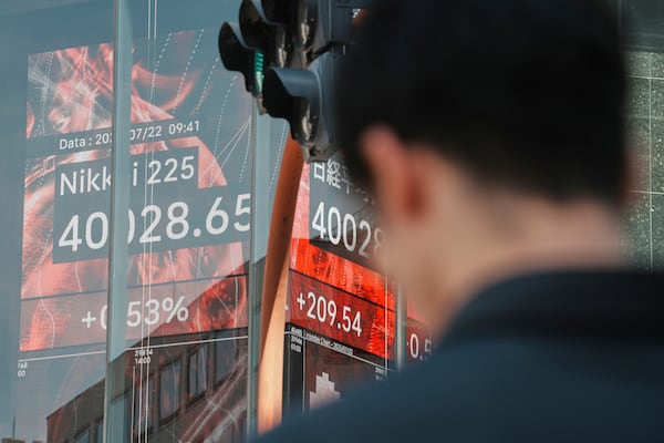 A person stands in front of an electronic stock board showing Japan's Nikkei index at a securities firm Tuesday, July 22, 2025, in Tokyo. (AP Photo/Eugene Hoshiko)
