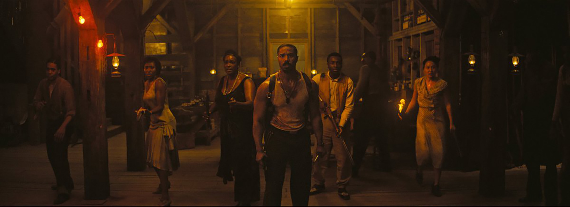 wide group shot of people in barn ready to fight