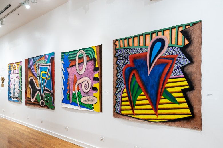 Four large-scale paintings hang on the wall. All are made in vibrant colors, with very expressive biomorphic shapes dancing across the canvas.