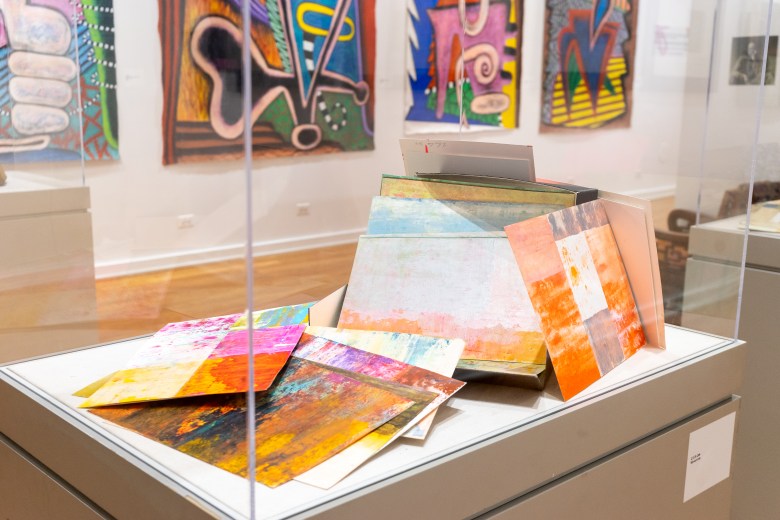 In a glass vitrine in the center of the galley are a spread of small color studies by Li Lin Lee, depicting washes of color, some are pale and others show bright oranges and pinks. Large paintings by Ho can be seen on the wall behind.