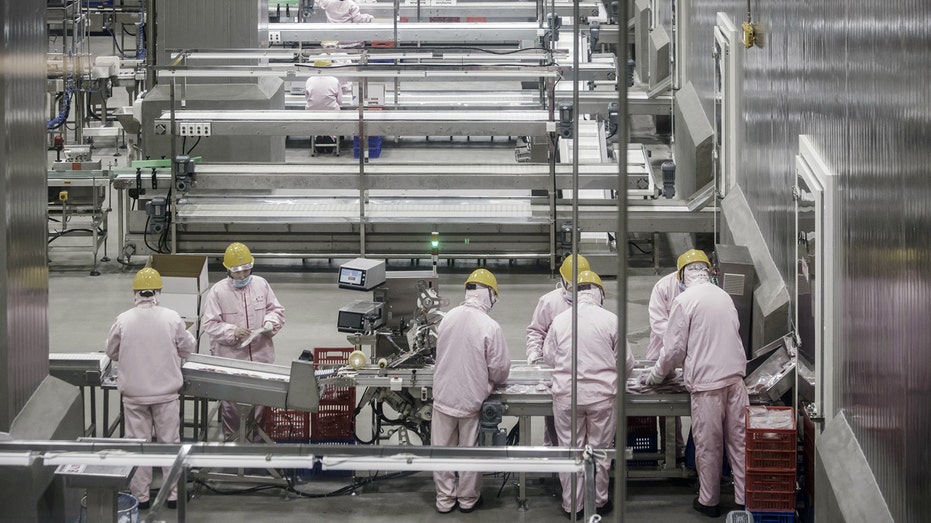 Employees process pork at a WH Group plant
