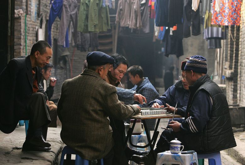 Residents play mahjong at an alley on January 15, 2005, in Chongqing, China.