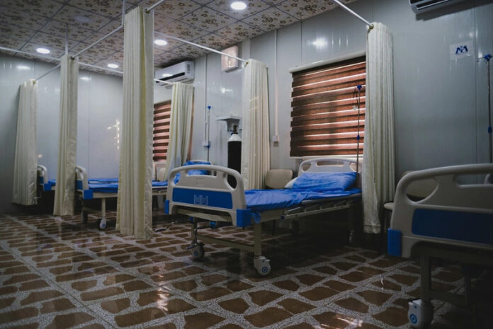 A hospital ward with empty beds.