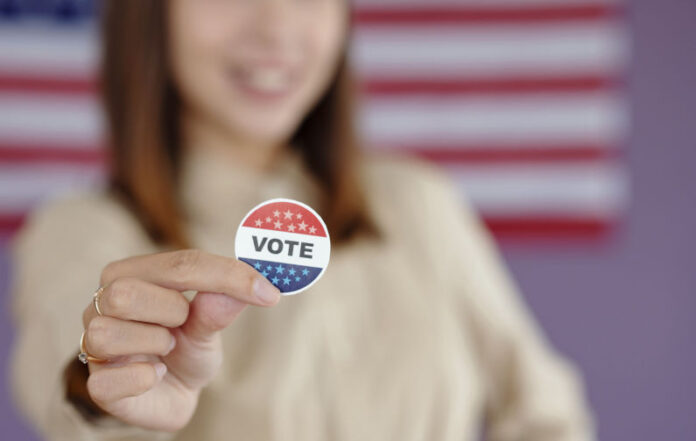Close-up of young voter holding patriotic pin